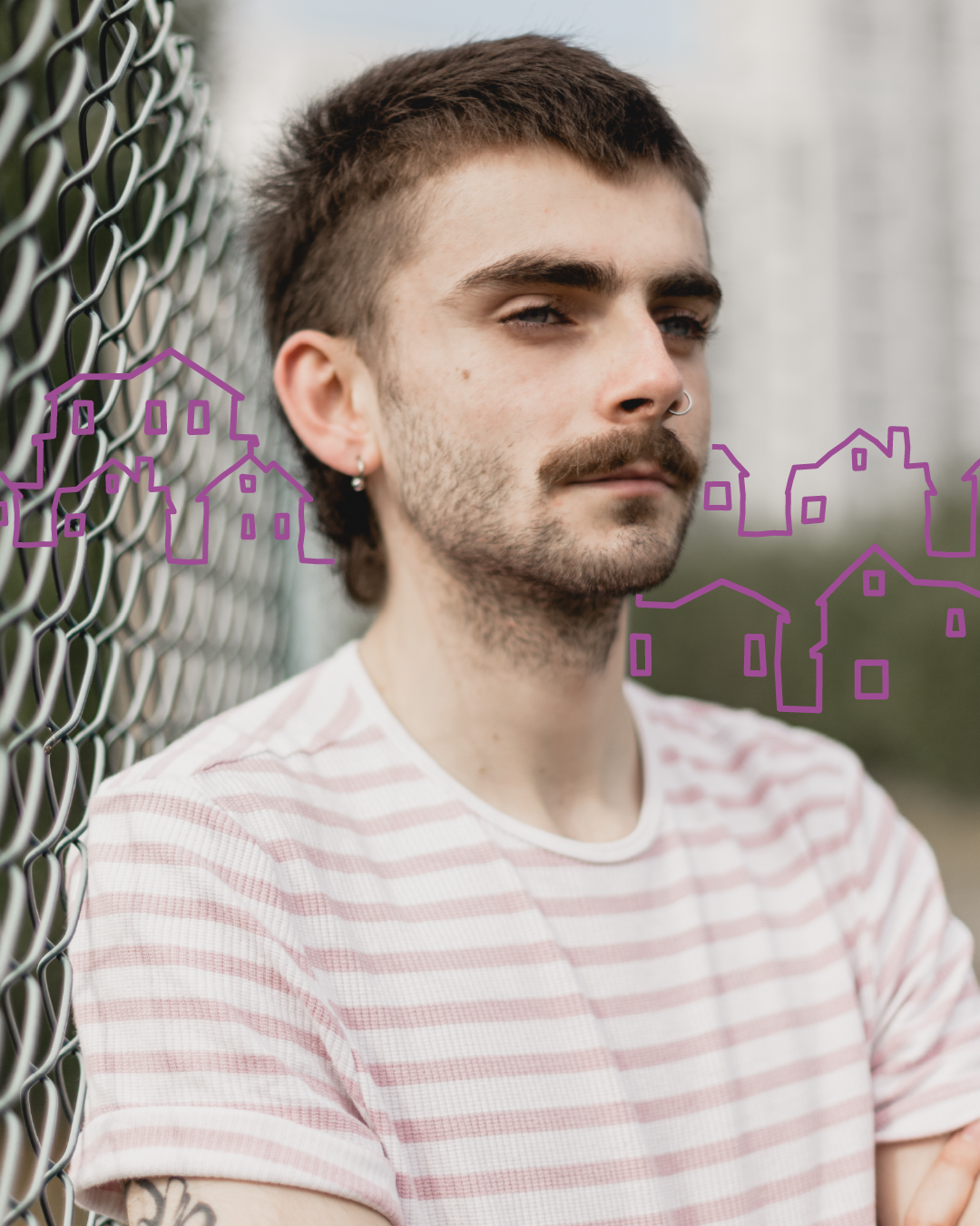 A young man with dark hair and facial hair stands in front of a mesh fence. There is a purple line illustration of houses in the background.