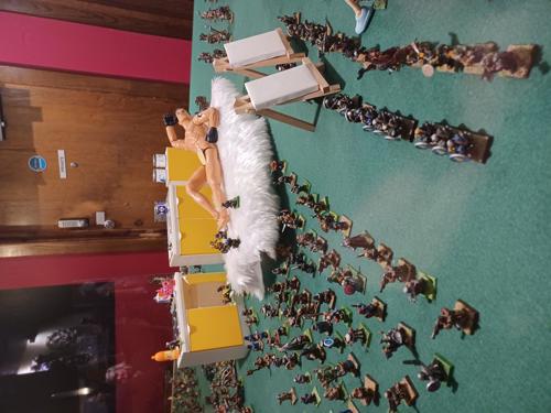 Action man lying on bed amongst Warhammer figurines