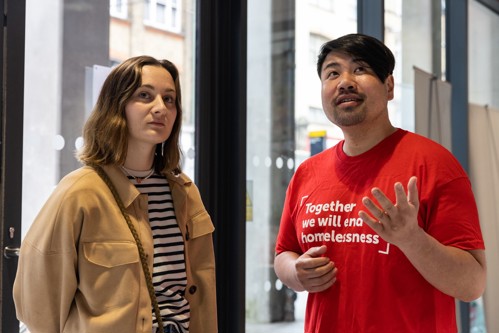 a member of a Crisis staff shows a woman around the London Skylight